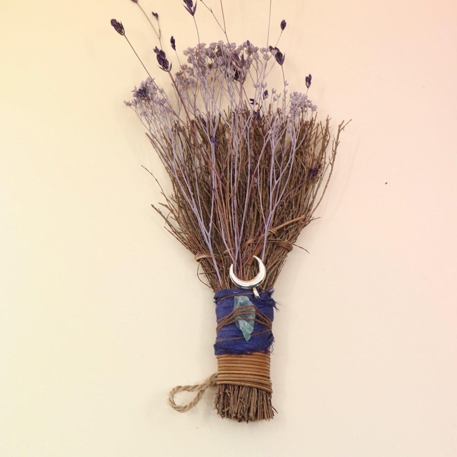 The Moon Besom Broom with Clear Quartz on a pink and yellow background.