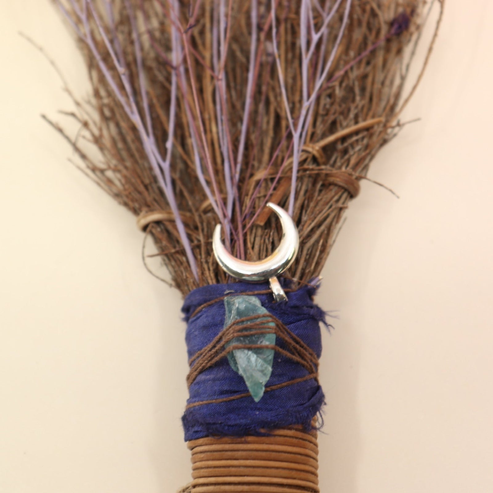The Moon Besom Broom with Clear Quartz on a pink and yellow background.