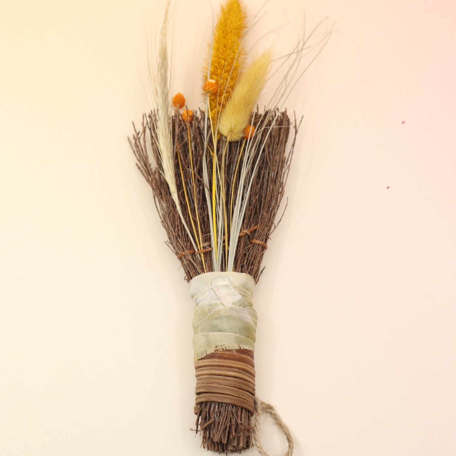 The Cinnamon Besom Broom with Quartz Healing Crystal on a pink and yellow background.