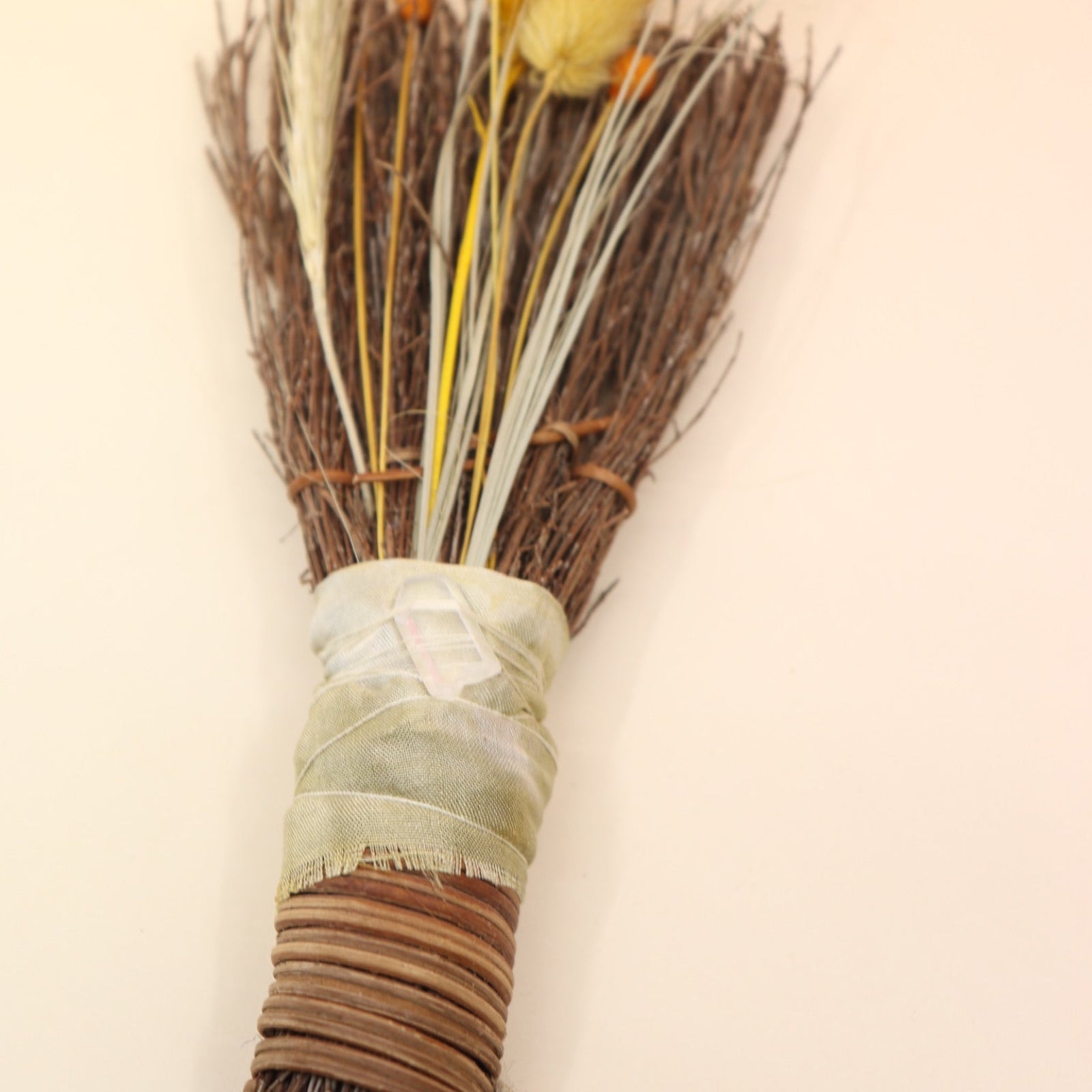 The Cinnamon Besom Broom with Quartz Healing Crystal on a pink and yellow background.