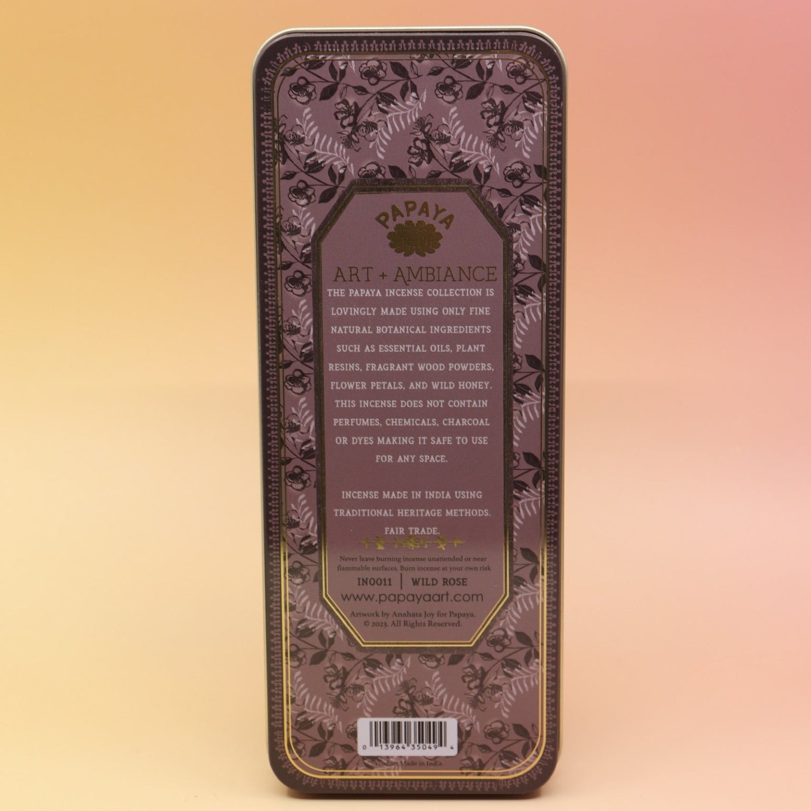 The Wild Rose Premium Incense on a pink and yellow background, showing off the back.