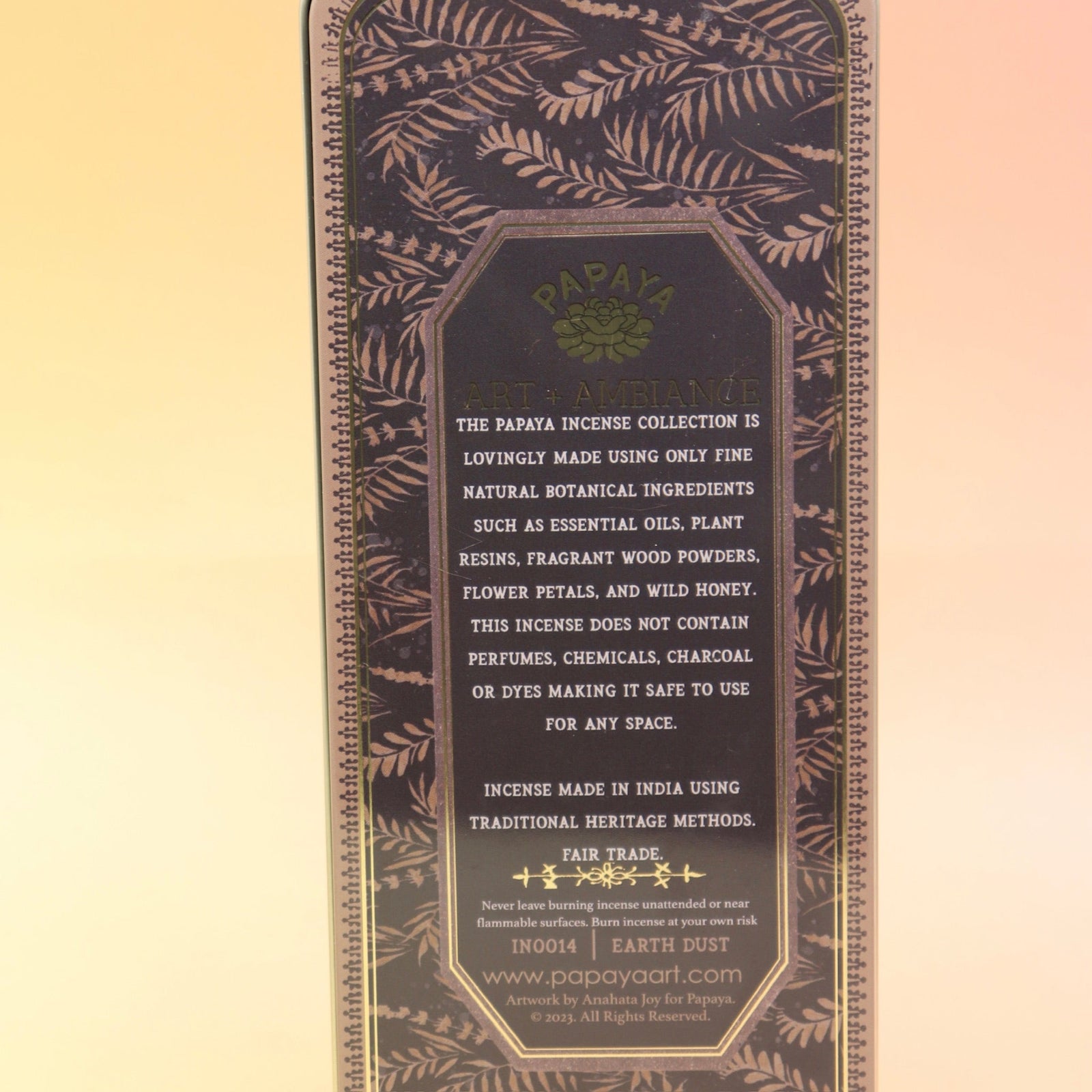 The Earth Dust Premium Incense on a pink and yellow background, showing off the back.