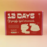 The back of the Googly & Bright Holiday Advent Calendar on a pink and yellow background.