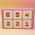 The Googly & Bright Holiday Advent Calendar on a pink and yellow background.