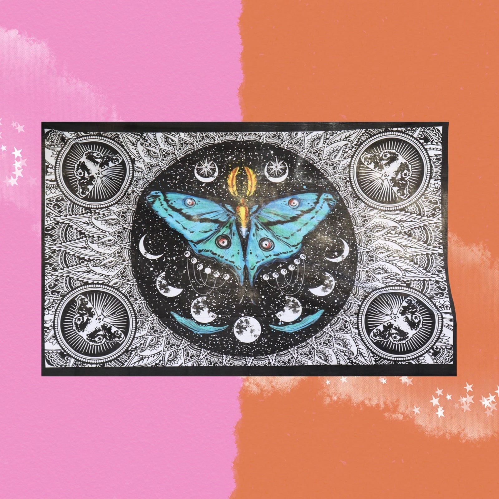 The Lunar Moth Cotton Tapestry in front of a pink and orange background.