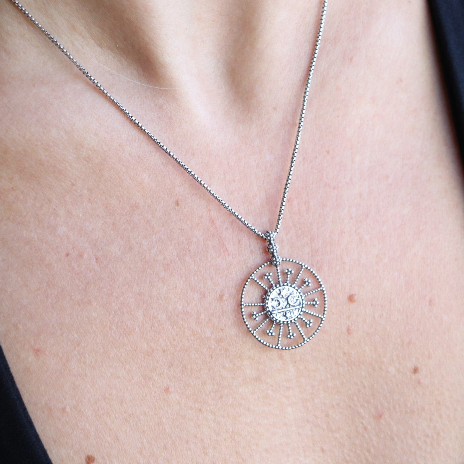 Someone wearing the Morgana's Spell Sterling Silver Necklace with a black top.