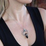 Someone wearing the Silver Thorn Crystal Necklace with a black tank.