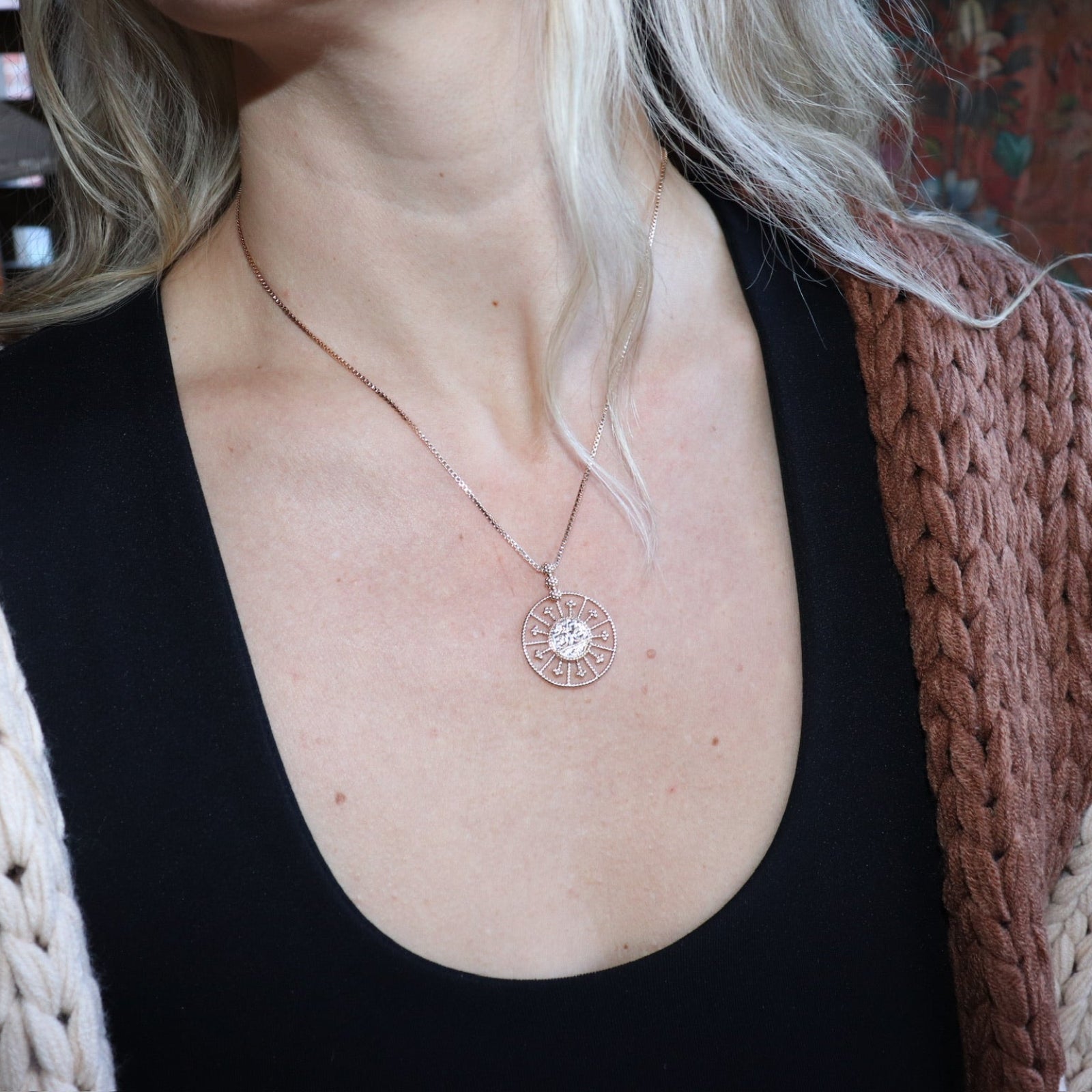 A woman wearing the Morgana's Spell Gold Necklace with a black tank and a cardigan.