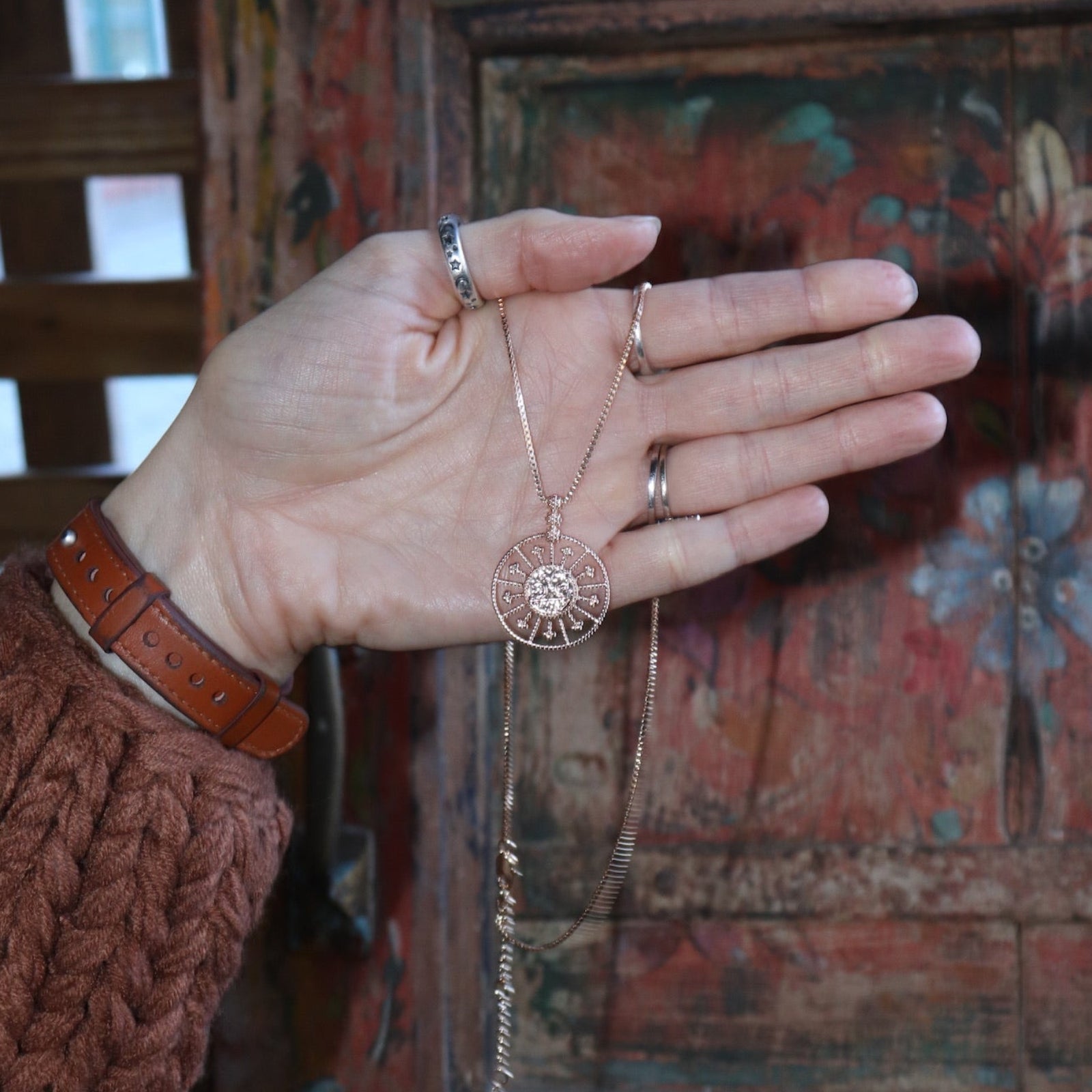 A woman holding the Morgana's Spell Gold Necklace.
