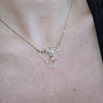 Someone wearing the Fairy Glen Gold Necklace with a black tank and a cardigan.