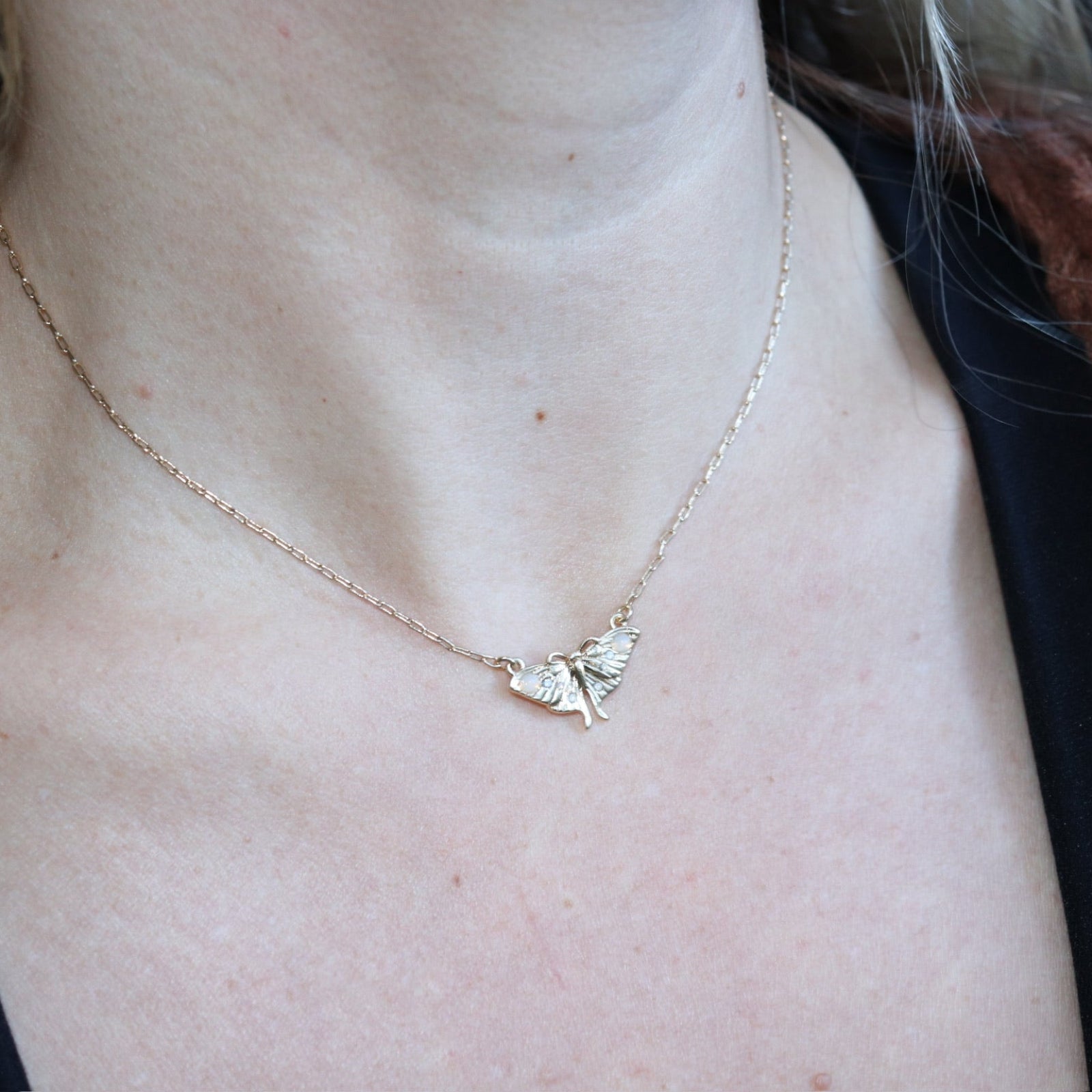 Someone wearing the The Moon Moth Dainty Gold Necklace.