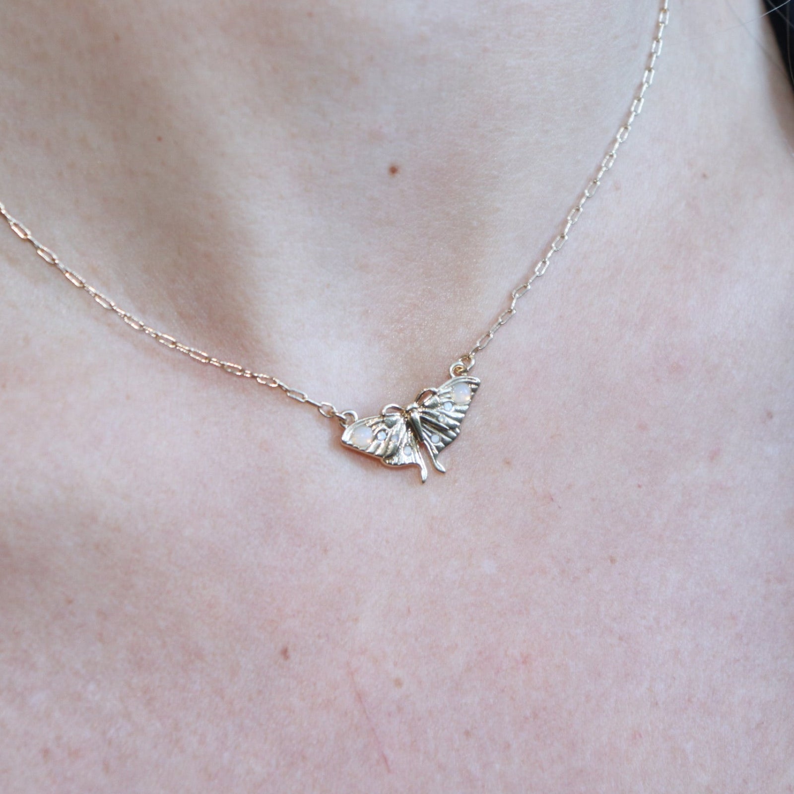 Someone wearing the The Moon Moth Dainty Gold Necklace.
