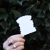 Someone the Rolling Fatties Funny Cat Sticker in front of a green bush, showing off the back.