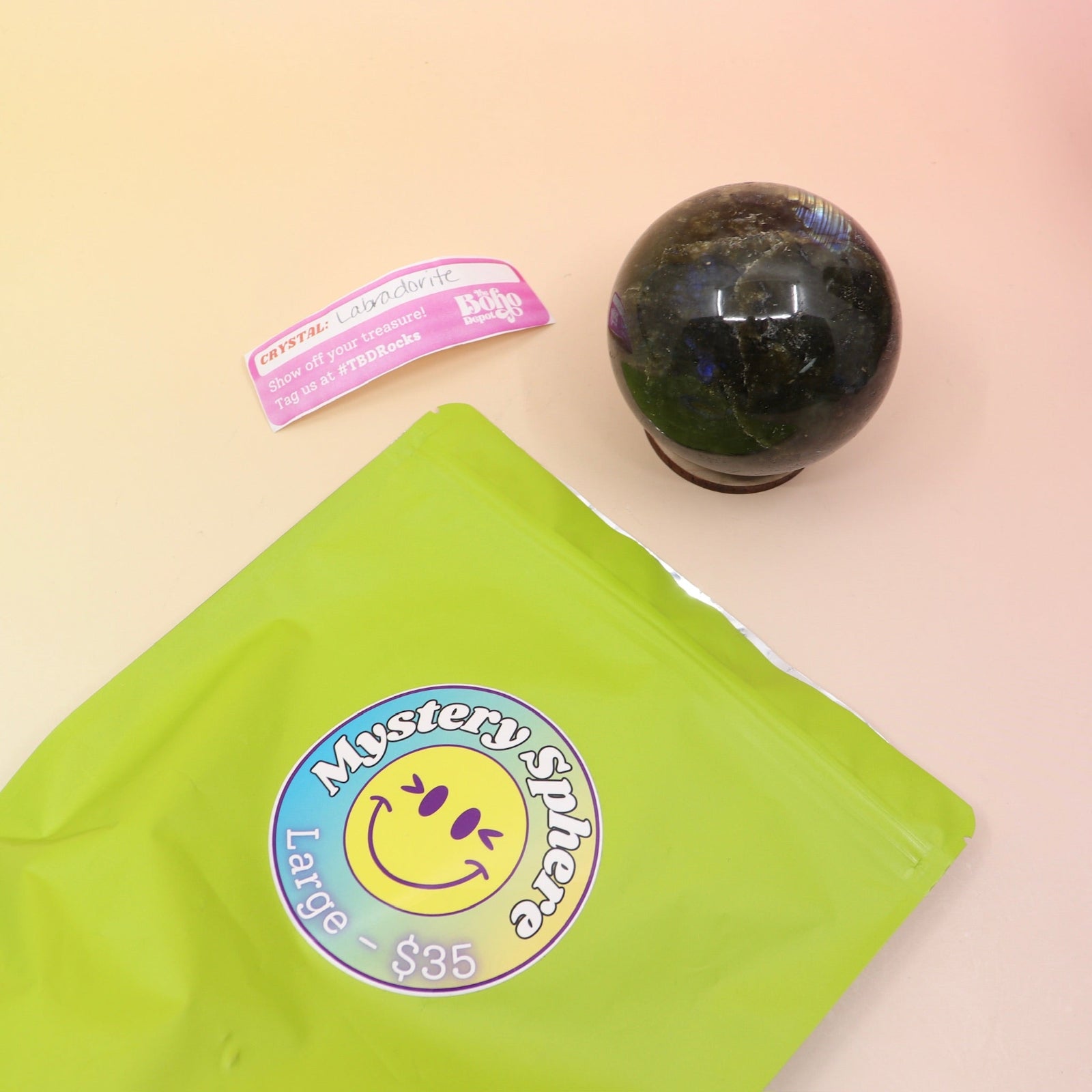 A large Mystery Crystal Sphere Bag open with its contents on a pink and yellow background.