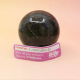 An up-close image of the large Mystery Crystal Sphere Bag's contents on a pink and yellow background.