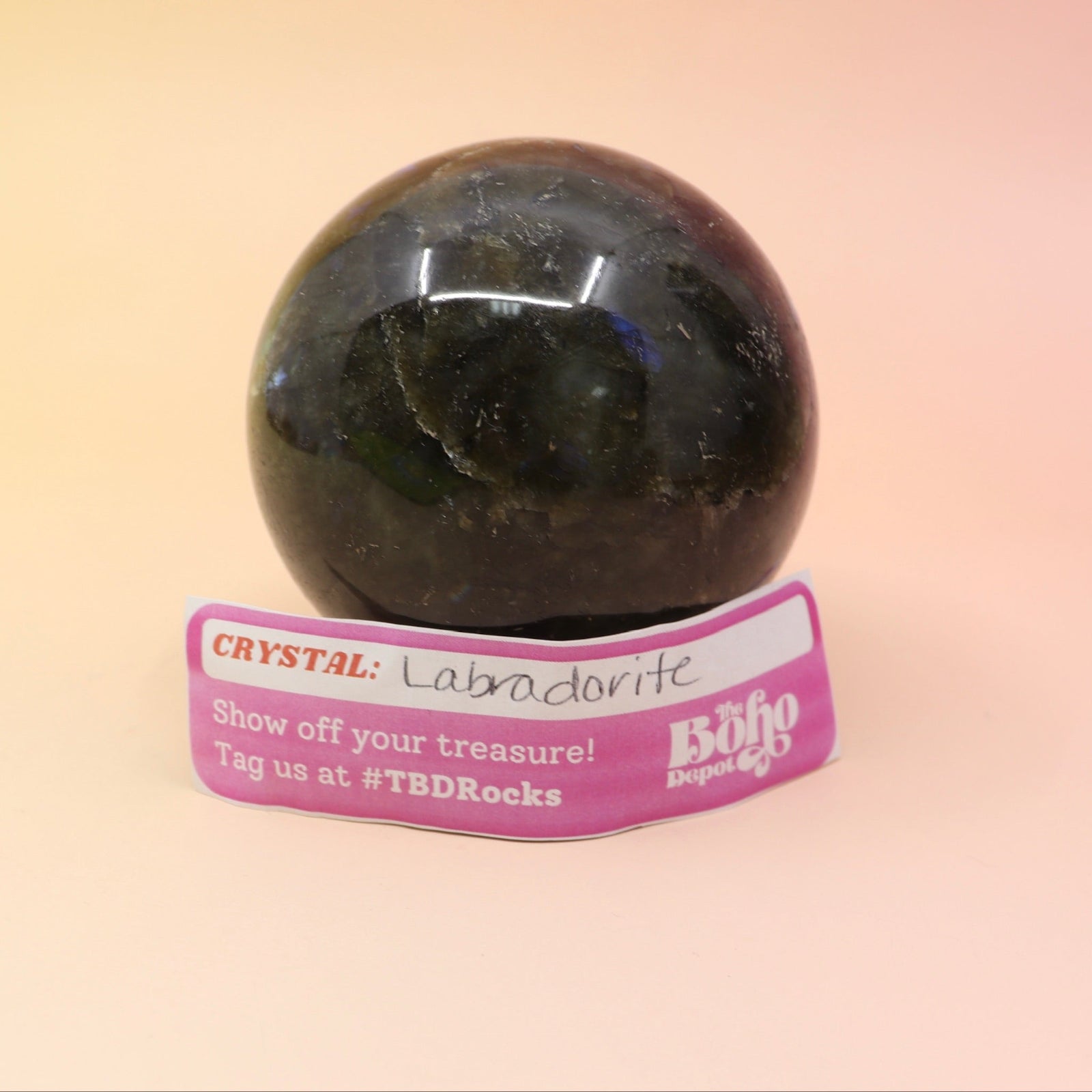 An up-close image of the large Mystery Crystal Sphere Bag's contents on a pink and yellow background.