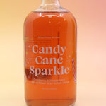 The Candy Cane Sparkle Cocktail & Mocktail Mixer on a pink and yellow background.