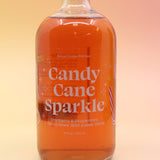 The Candy Cane Sparkle Cocktail & Mocktail Mixer on a pink and yellow background.