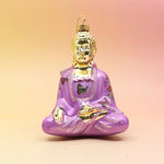The pink Buddha with Butterfly Glass Ornament on a pink and yellow background.