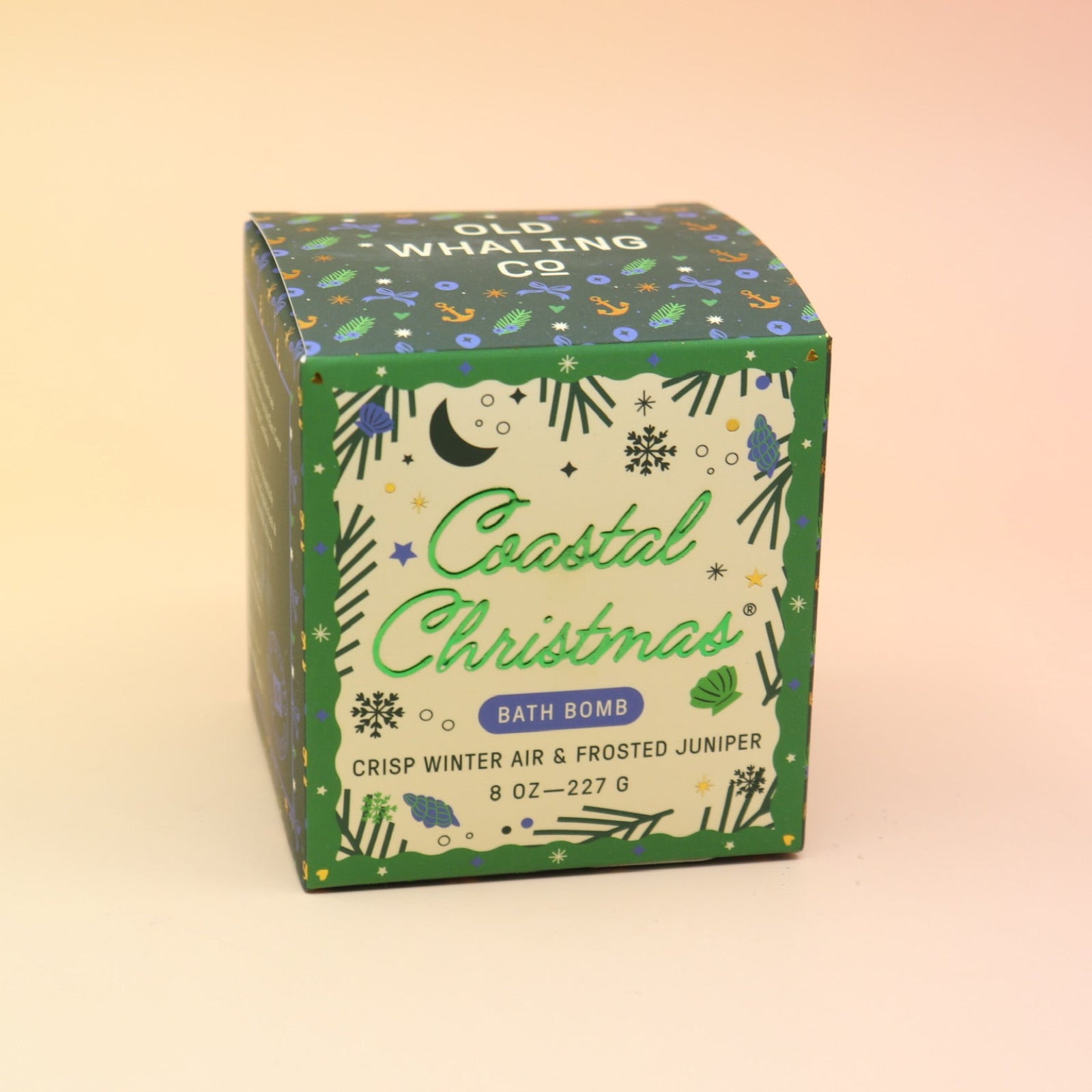 The Coastal Christmas Holiday Bath Bomb in front of a pink and yellow background.
