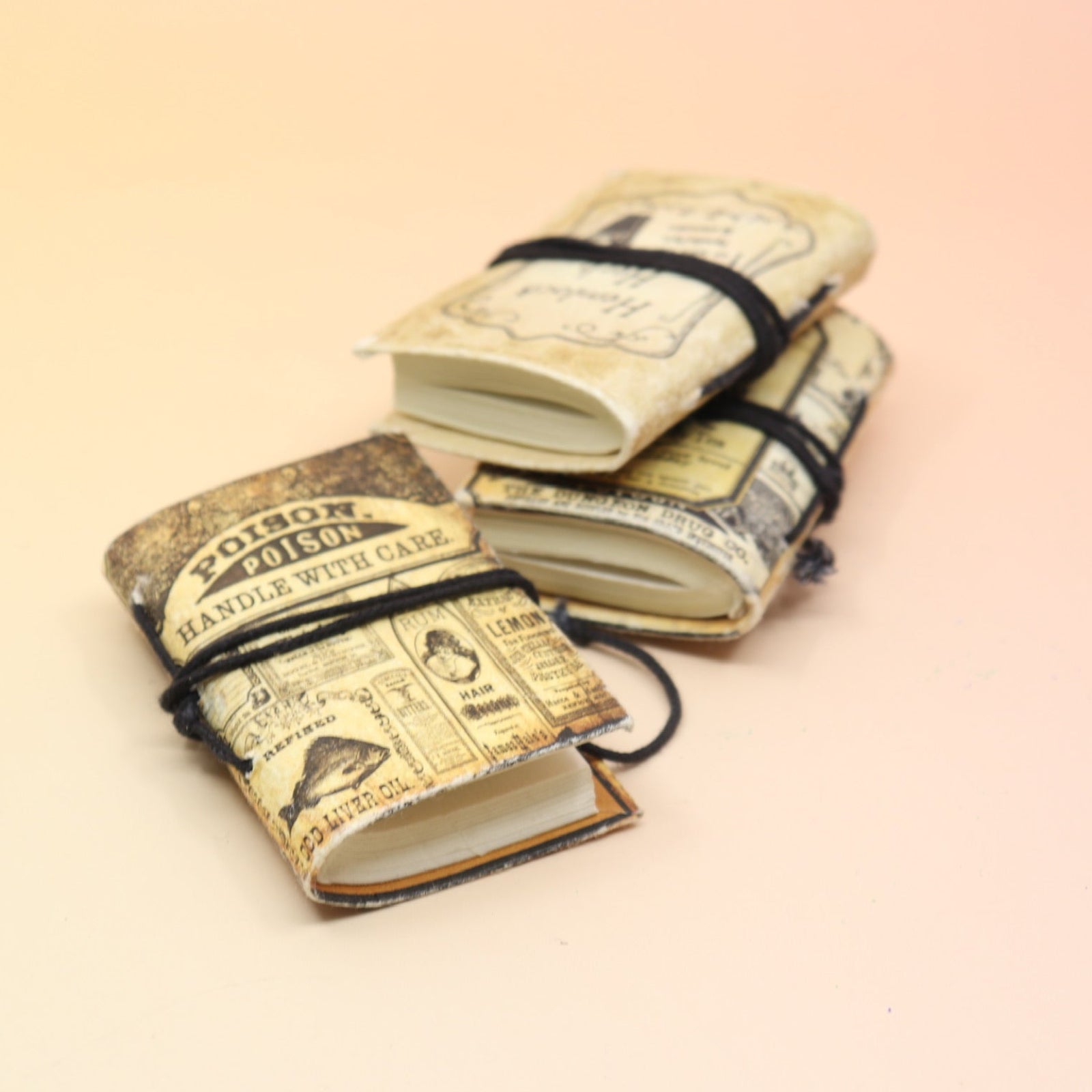 Three of the Lotions & Potions Mini Journals on a pink and yellow background.