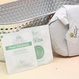 The contents of the Holiday Hammered Windowsill Rosemary & Sage Growing Kit on a pink and yellow background.