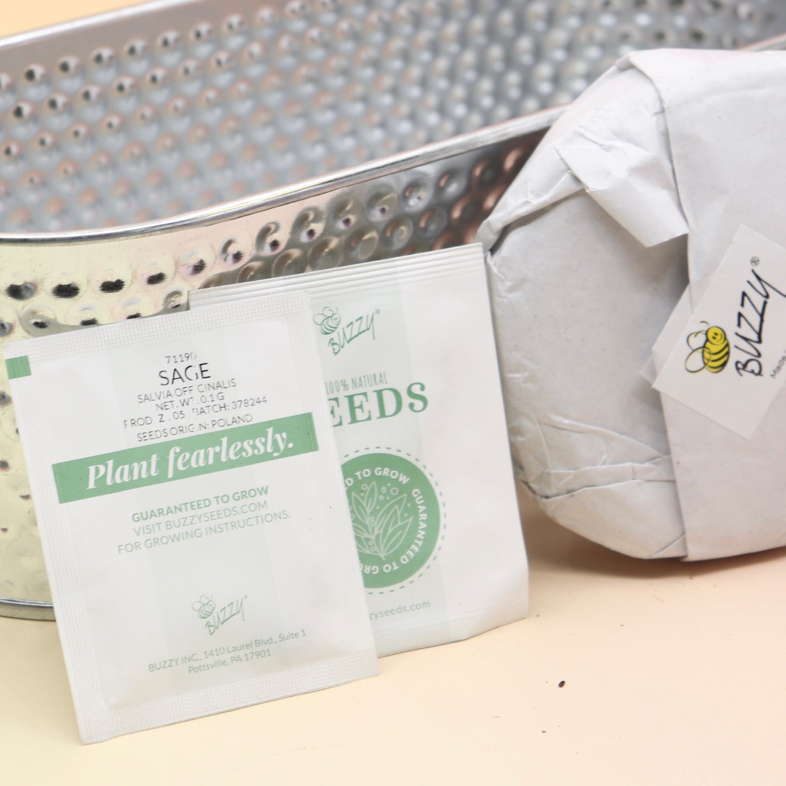 The contents of the Holiday Hammered Windowsill Rosemary & Sage Growing Kit on a pink and yellow background.