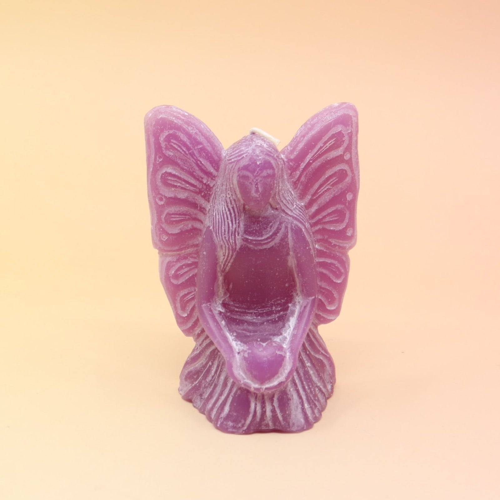 The purple Fairy Candle on a pink and yellow background.