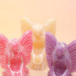 All three colors of the fairy candles on a pink and yellow background.