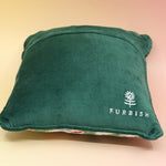 The Bless Your Heart Needlepoint Pillow on a pink and yellow background, showing off the back.