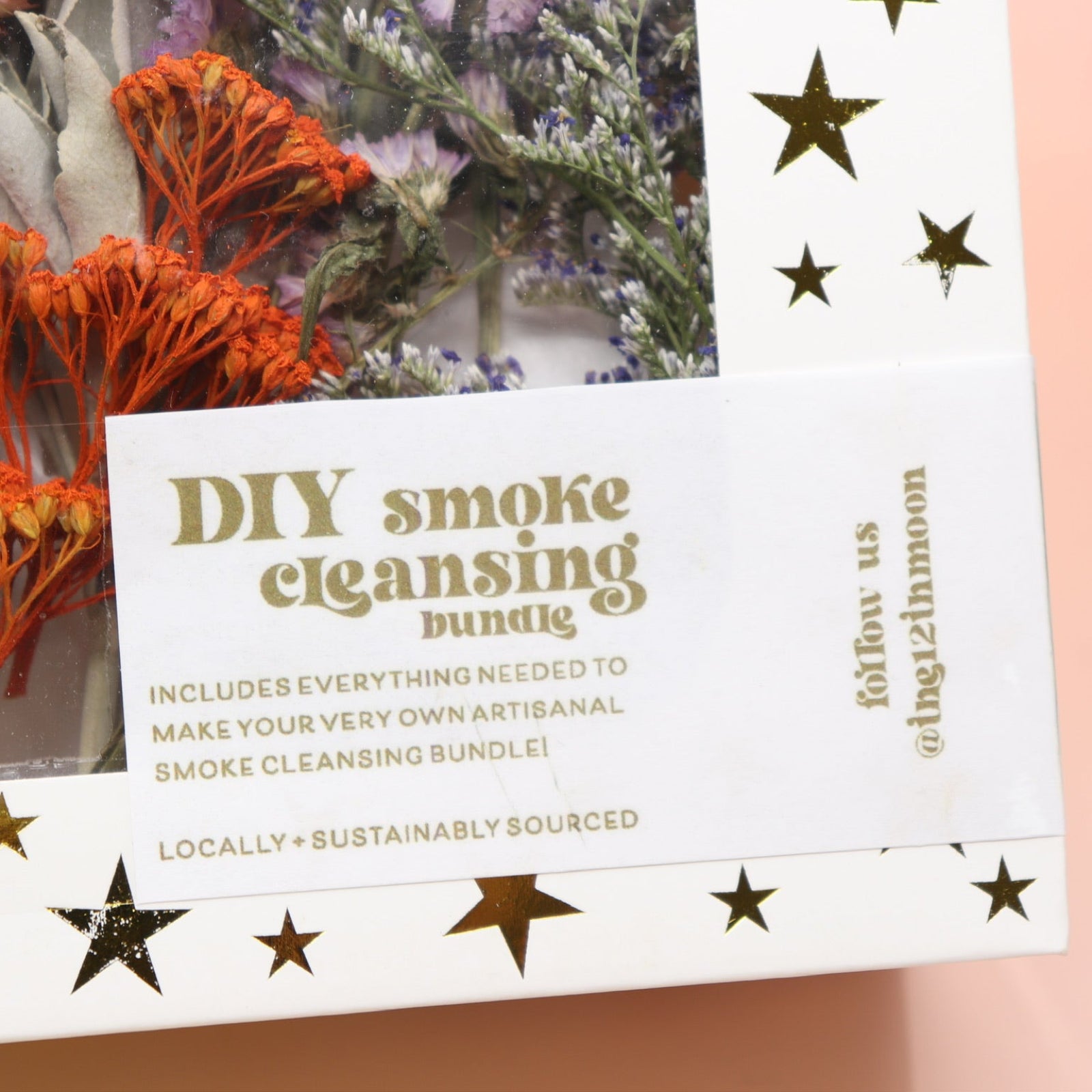 An up-close image of the DIY Smoke Cleansing Smudge Kit on a pink and yellow background.