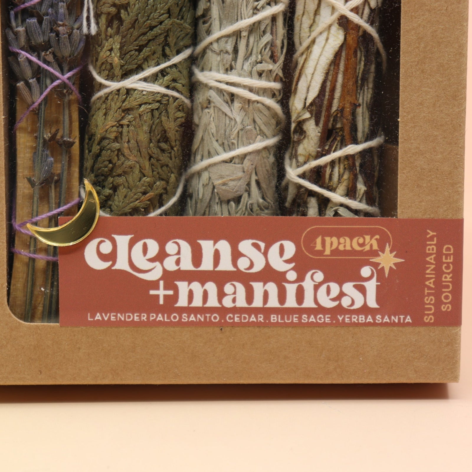 An up-close image of the Cleanse & Manifest Smudge Bundle Kit on a pink and yellow background.