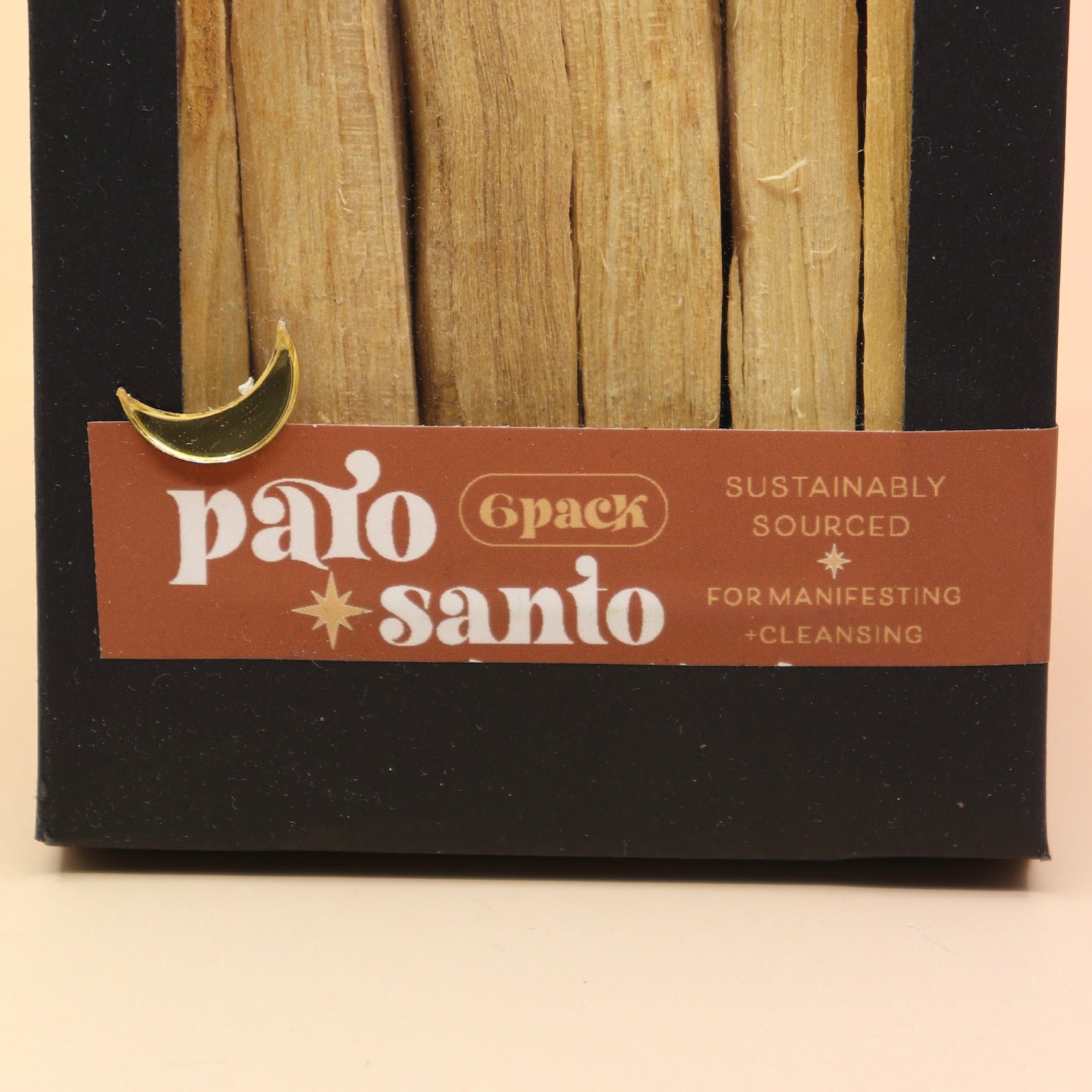 An up-close image of the 6 Pack Palo Santo Cleansing Bundle on a pink and yellow background.