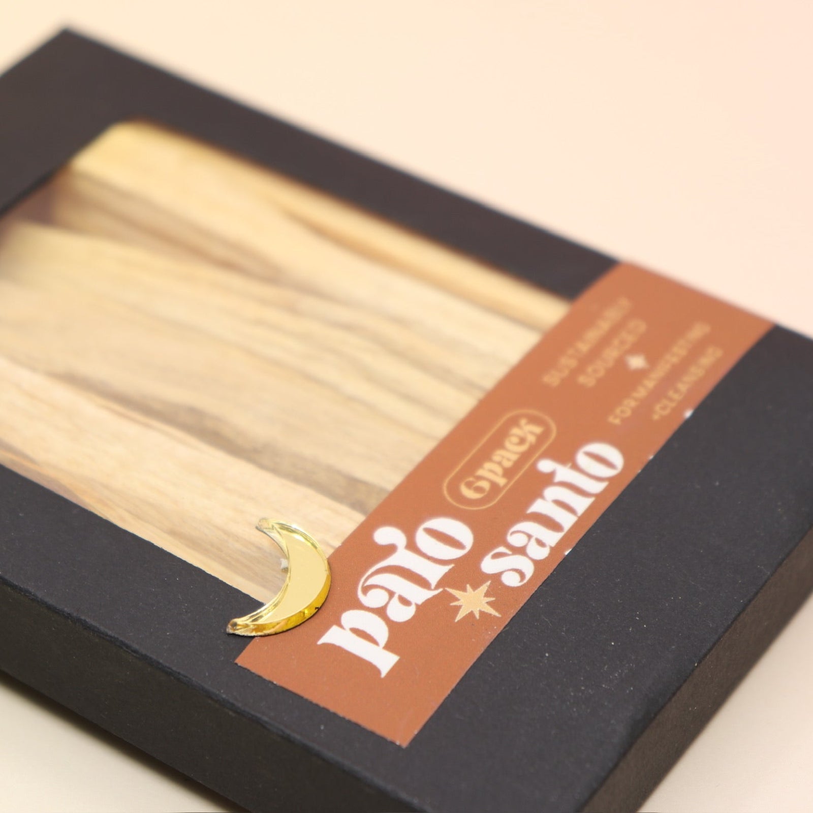 An up-close image of the 6 Pack Palo Santo Cleansing Bundle on a pink and yellow background.