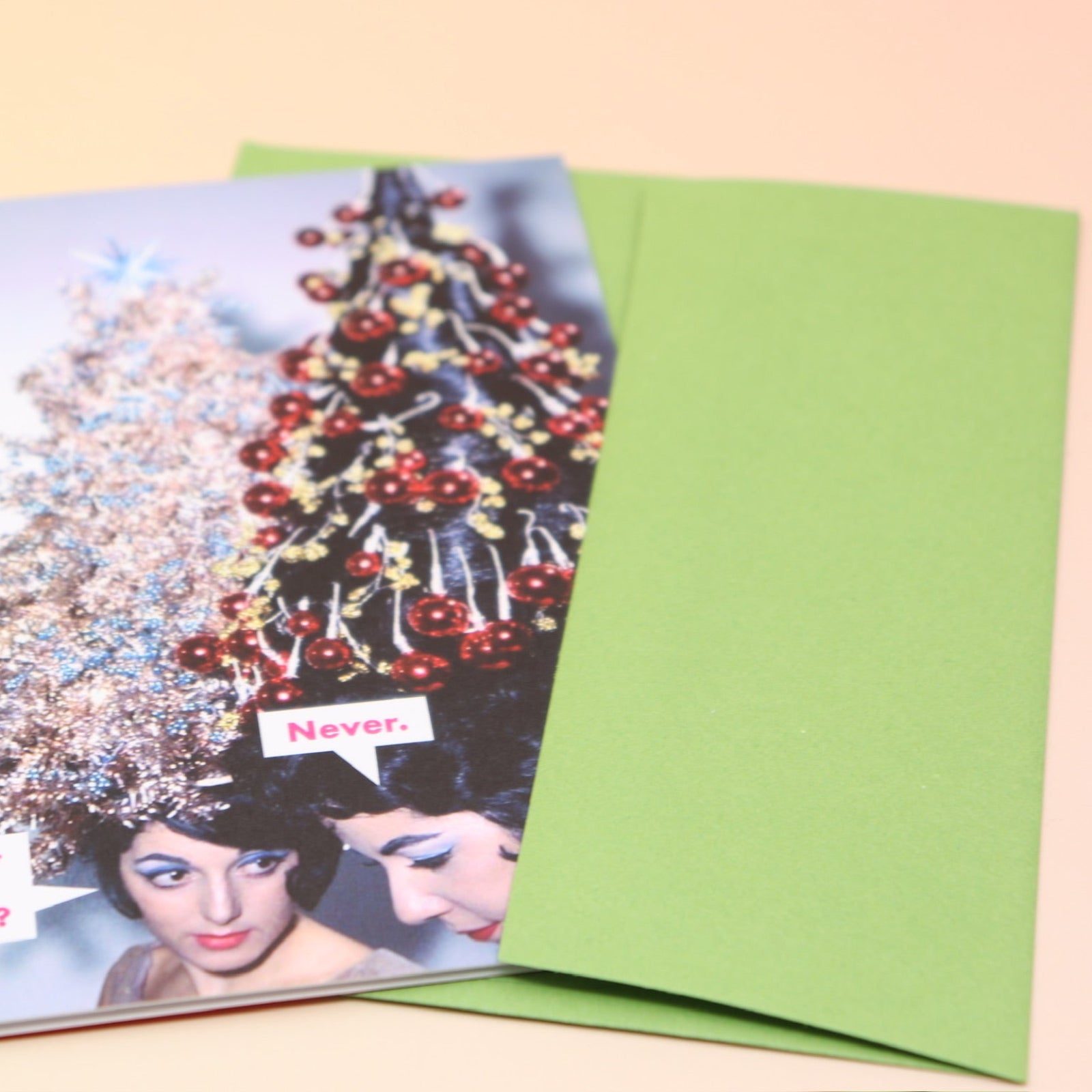 The Never. Christmas Card with its envelope on a pink and yellow background.