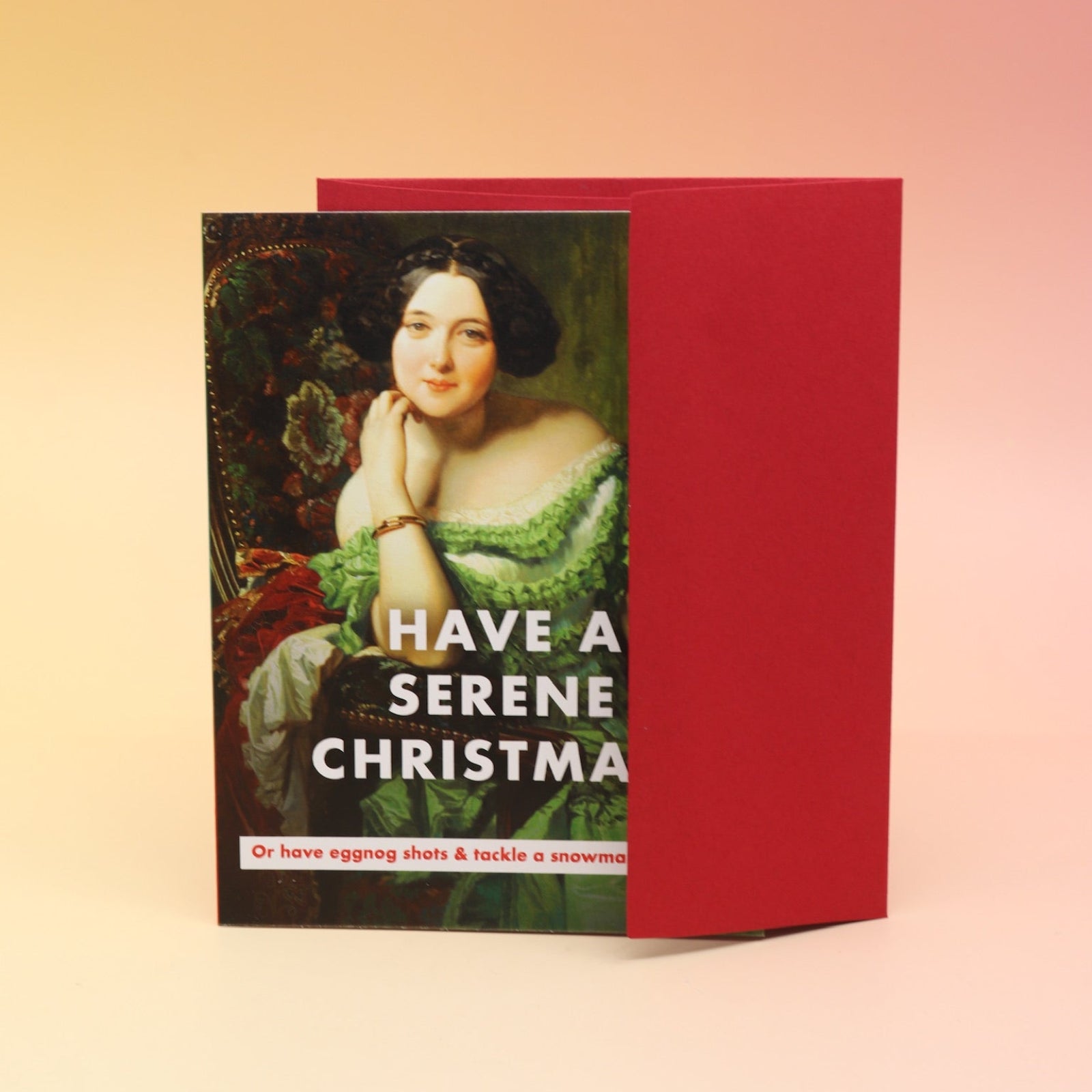 The Have a Serene Christmas Card with its envelope on a pink and yellow background.