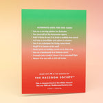 The back of The Calm the F*ck Down Christmas Card on a pink and yellow background.