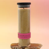 The Rapture Beeswax Aromatherapy Sanctuary Glasses on an agate slice all on a pink and yellow background.