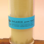 The Awaken Beeswax Aromatherapy Sanctuary Glasses on an agate slice all on a pink and yellow background.