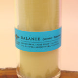 The Awaken Beeswax Aromatherapy Sanctuary Glasses on an agate slice all on a pink and yellow background.