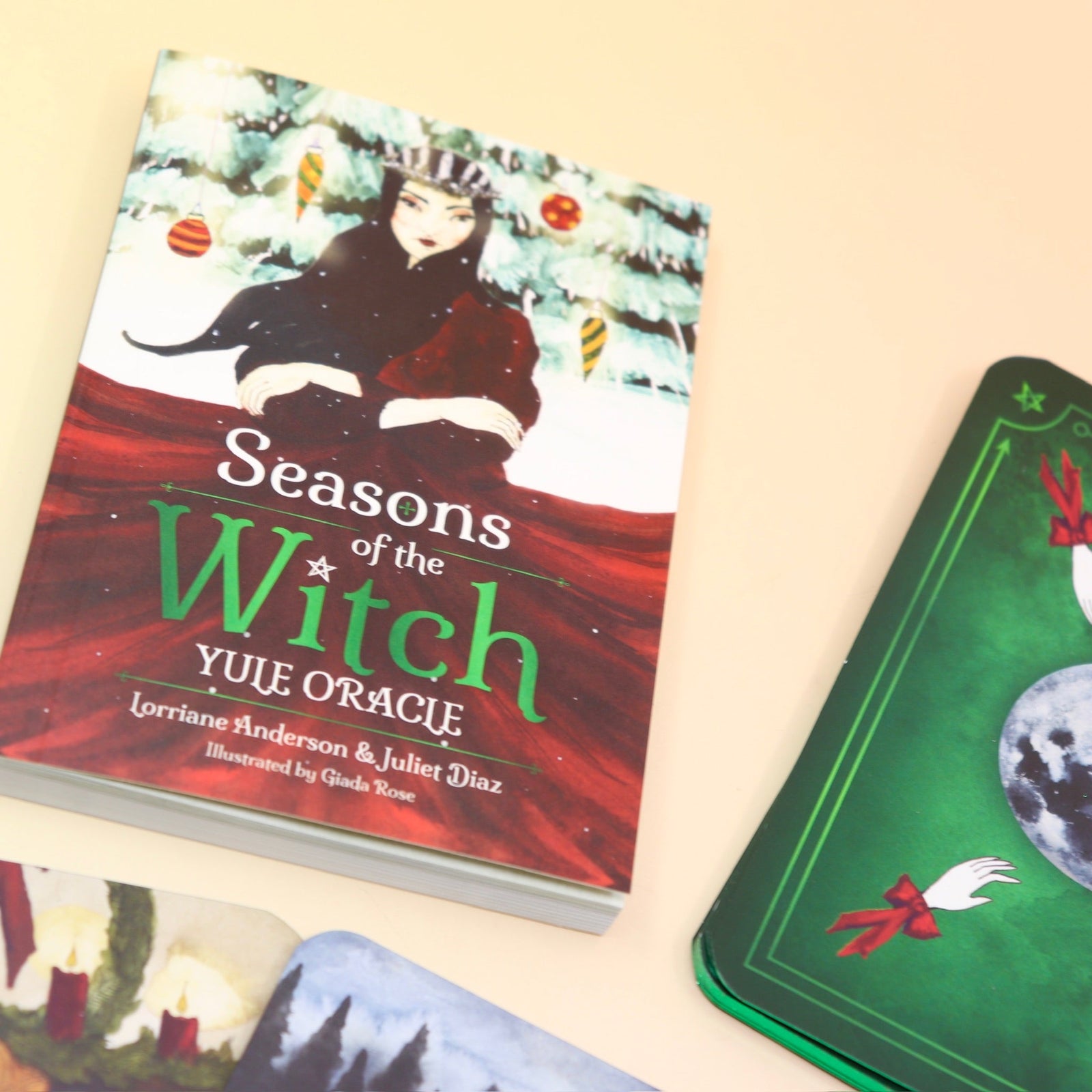 The contents of the Seasons of the Witch Yule Oracle Card Deck on a pink and yellow background.