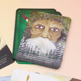 The contents of the Seasons of the Witch Yule Oracle Card Deck on a pink and yellow background.