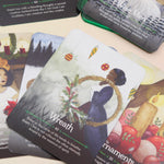 The contents of the Seasons of the Witch Yule Oracle Card Deck on a pink and yellow background.