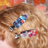 A woman wearing two of the clips from the Tackle Box Fish Clip Set.