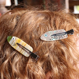 A woman wearing two of the clips from the Tackle Box Fish Clip Set.
