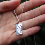 Someone holding the The Lovers Tarot Sterling Silver Necklace.