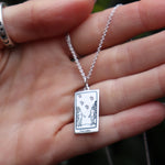 Someone holding the The Lovers Tarot Sterling Silver Necklace.