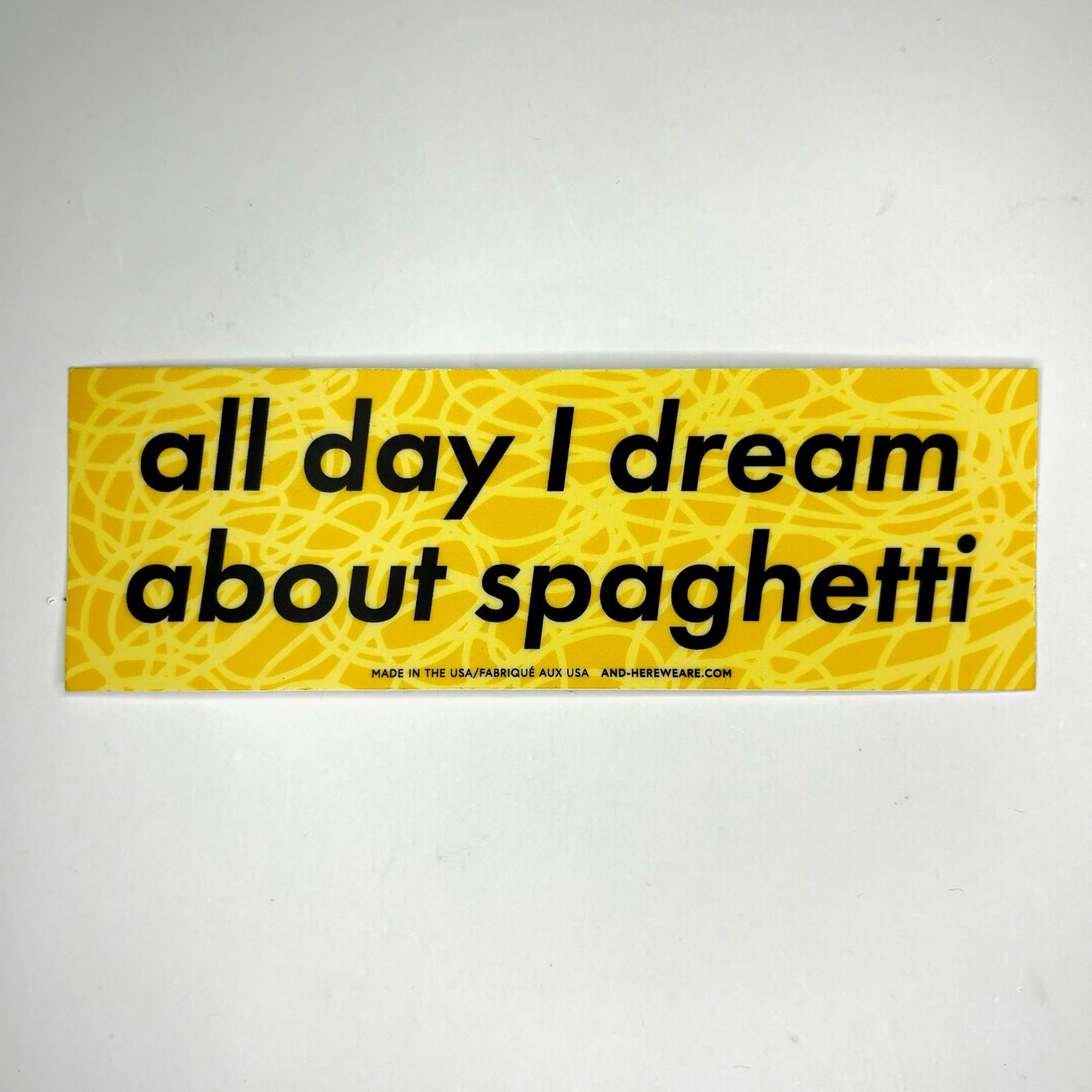 The All Day I Dream About Spaghetti Vinyl Bumper Sticker on a gray background.