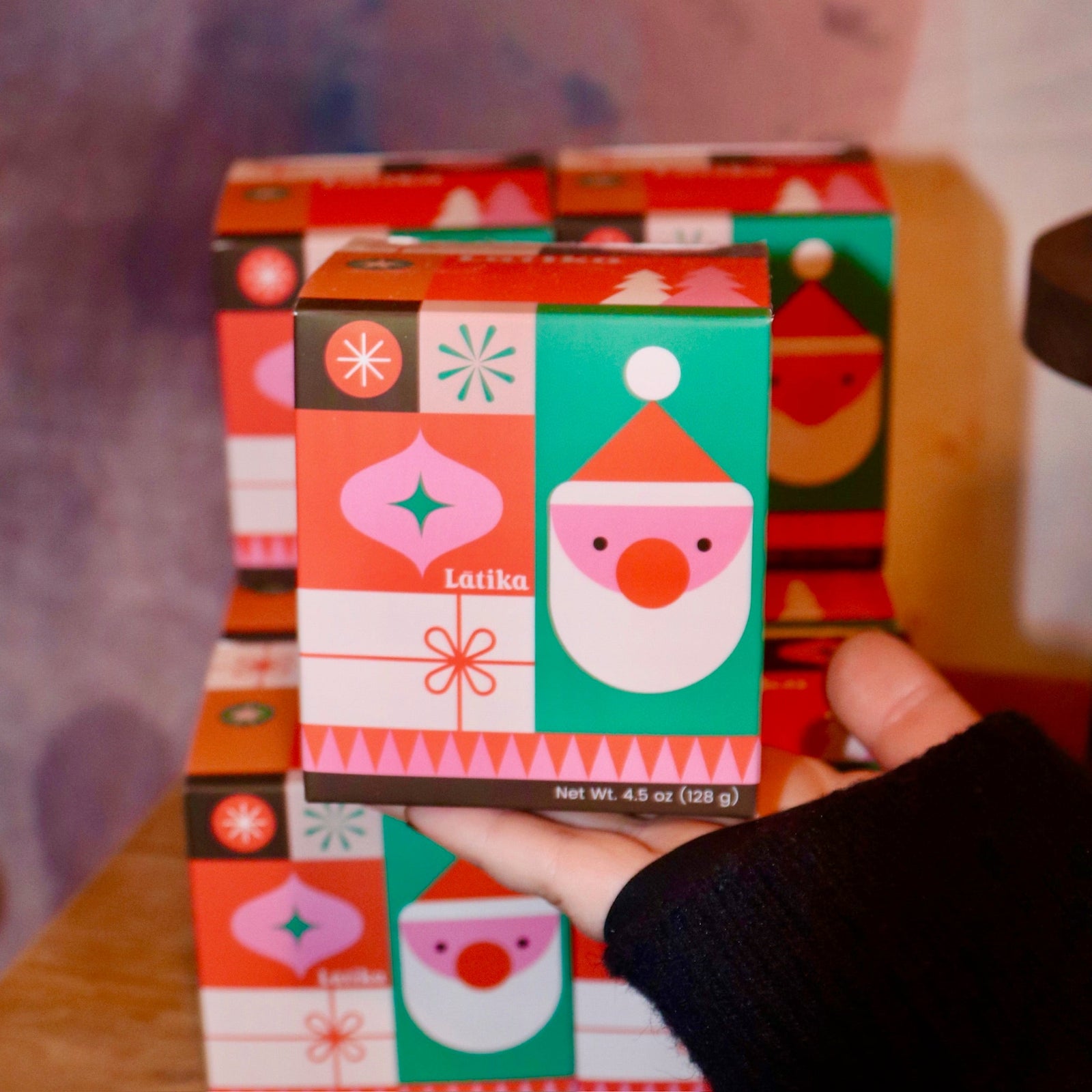 Someone holding the Geometric Santa Bath Bomb in front of other bath bombs.