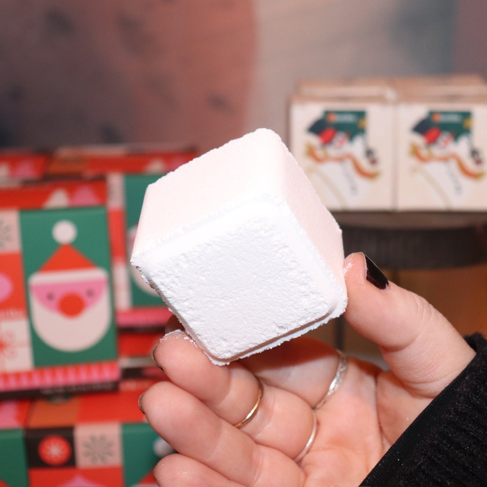 Someone holding the Snow Shower Steamer in front of other shower steamers.